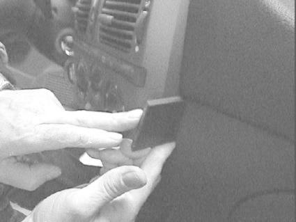 En hand placerar en del på en inredning i en Fiat Brava/Bravo.