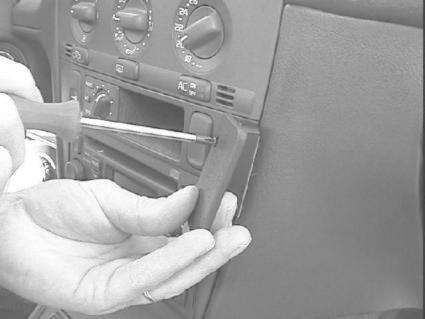 Bild på en man som använder en skruvmejsel för att ta bort panelen i en Volvo S40 96-00.