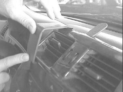 En person justerar en del av instrumentbrädan i en Nissan Terrano II.