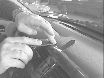 Händer applicerar något på interiören i en Nissan Terrano II.