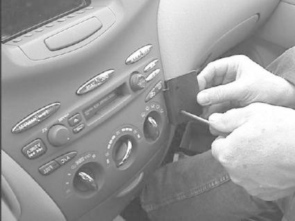 En hand installerar en monteringsbygel i en bilkonsol.