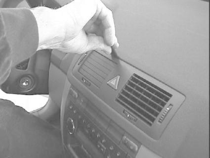 En hand justerar en del av bilens instrumentpanel.
