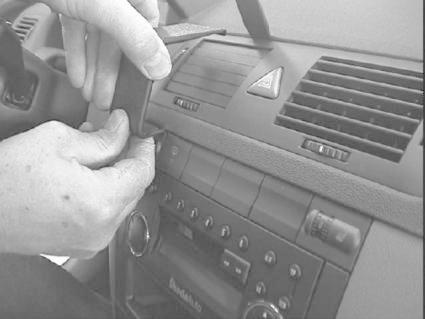 Man sätter fast en monteringsbygel på en bilradio i en Skoda Fabia.