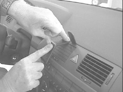 Händer installerar monteringsbygel på instrumentbrädan i en Skoda Fabia.