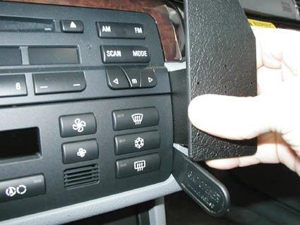 Bild av bilkontrollpanel med knappar och hand som öppnar ett lock.