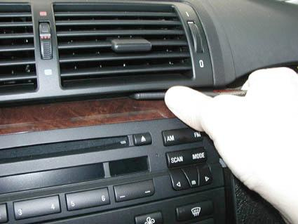 En hand justerar kontrollerna på instrumentpanelen i en BMW E46.