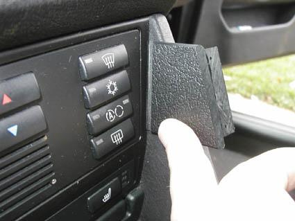 En hand trycker på en panel med kontrollknappar i en BMW E39.