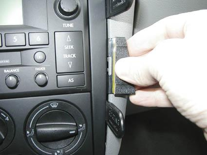 En hand som sätter in en enhet i en bilpanel av Volkswagen Golf IV/Bora.