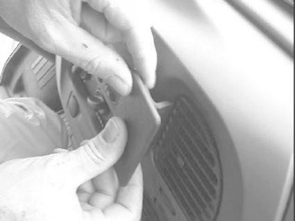 En manlig hand fäster en del vid en ventil i ett fordon.