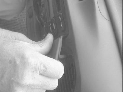 En hand justerar knappar på en inredning i en Ford Transit 00-06.