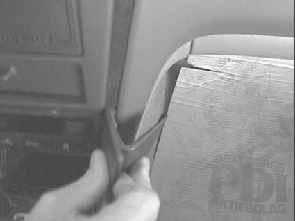 En hand som håller i ett verktyg nära en bilinteriör.