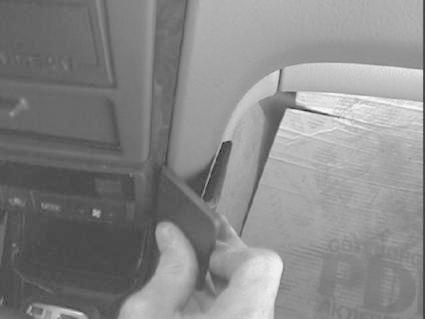 En hand håller i en vinklad monteringsbygel för Nissan Maxima.