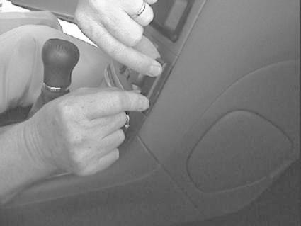 Hand som justerar en kontroll eller knapp på en bils interiör.