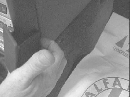 En hand håller en vinklad monteringsbygel för Alfa Romeo.