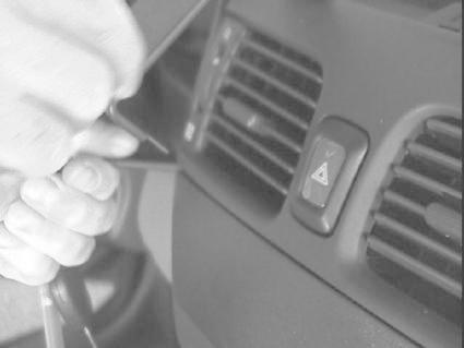 Händer som håller en verktyg vid instrumentpanelen i en Nissan Almera.