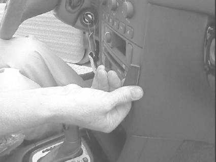 En hand som justerar en kontroll i en bilinteriör.