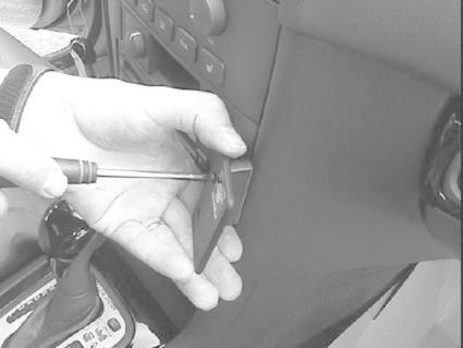 En hand använder en skruvmejsel på en panel i en Volvo S40/V40.