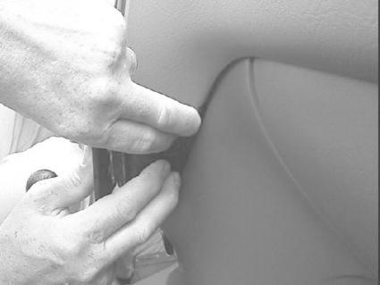 En hand som justerar eller fäster något i Honda CR-V 97-01 interiör.