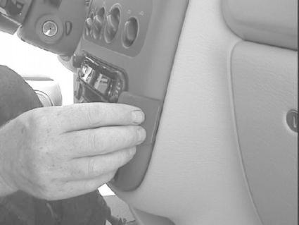 En hand justerar en del av instrumentpanelen i en Chrysler PT Cruiser.