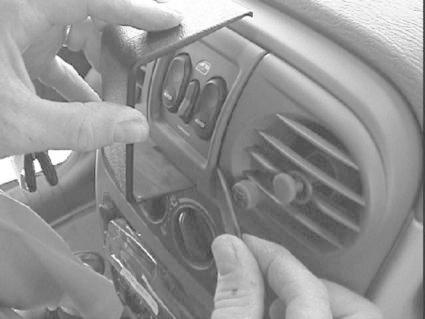 Händer arbetar med bilens instrumentpanel och kontroller.