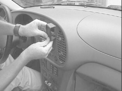 En person installerar komponenter i instrumentbrädan på en Saab 9-3.