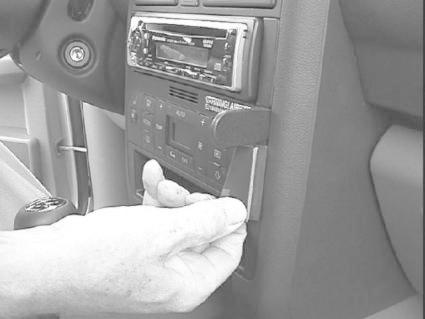 En hand justerar en bilradio på instrumentbrädan i en Audi A2.