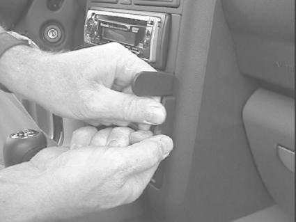 En person installerar något i instrumentpanelen på en Audi A2.