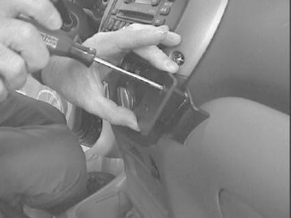 En person använder en skruvmejsel för att arbeta med bilen.