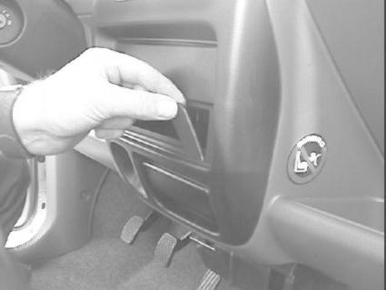 En hand monterar en bygel i en bils instrumentbräda.