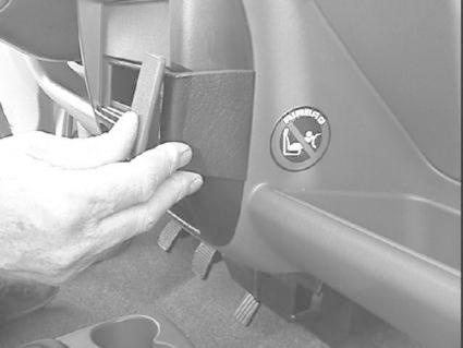 En hand fäster en monteringsbygel i en bilinteriör.