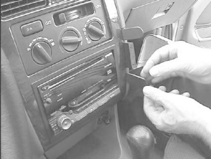 En person hanterar en bilradio i en Toyota Avensis interiör.