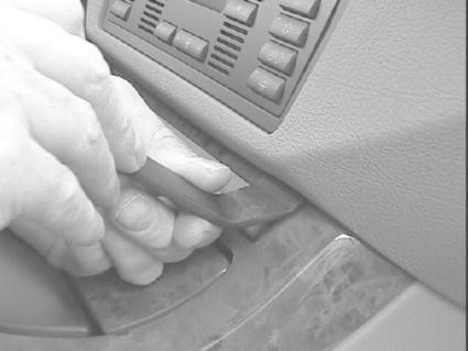 En hand använder ett verktyg för att justera bilens inredning.