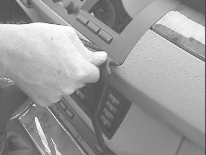 Hand som justerar en del av instrumentpanelen i en BMW X5.