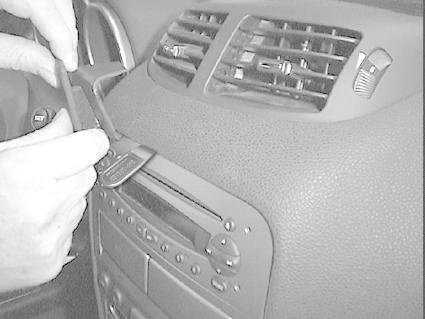 En hand justerar kontrollpanel i en Alfa Romeo 147/GT.