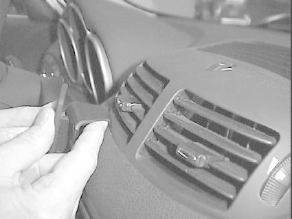 En hand justerar luftventilen i en Alfa Romeo interiör.