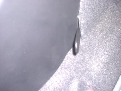 En del av bilinteriören, troligtvis en matta eller panel.