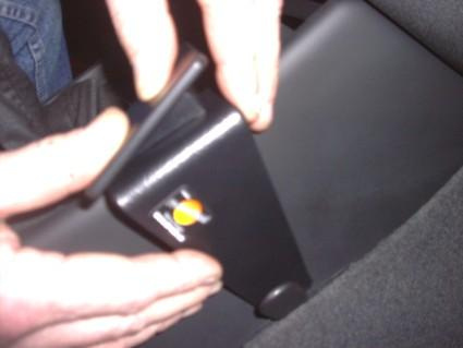 En hand som justerar en del av en bilinsats med en knapp.