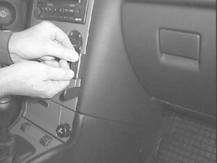 En person justerar en knapp eller kontakt i en Opel Astra från 98-03.