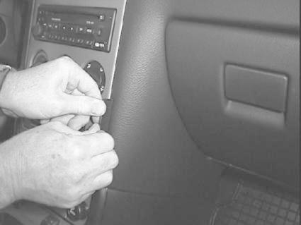 En person arbetar med bilens interiör, troligen med ljudsystemet.