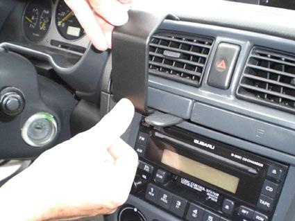 En hand monterar panel i en bil, specifikt en Subaru Impreza 01-04.