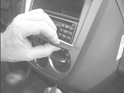 En hand justerar en del av bilens instrumentpanel.