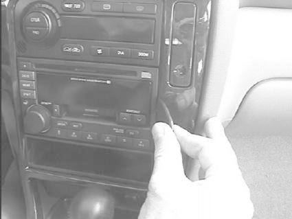 En hand justerar en kontrollpanel i en Subaru Outback/Legacy 99-03.