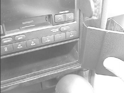 En del av instrumentbrädan med knappar och en hållare.