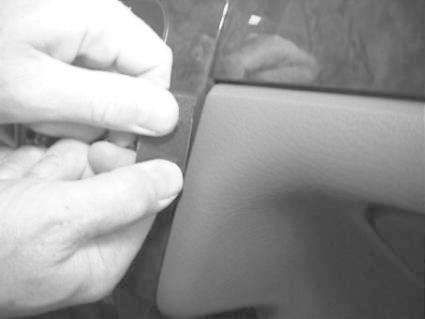 En hand fäster en del på en bilinteriör.