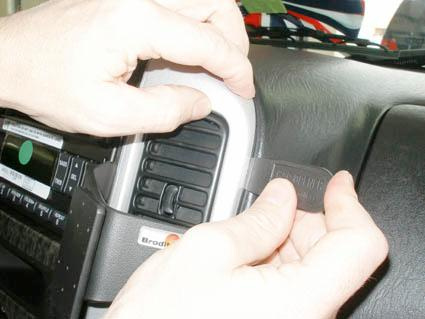 Två händer installerar en monteringsbygel vid en bilventil.