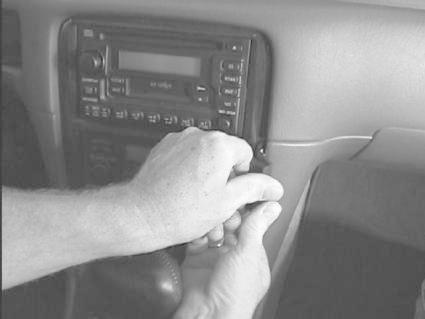 En person tar bort en bilstereo från en Toyota Camry 97-01.