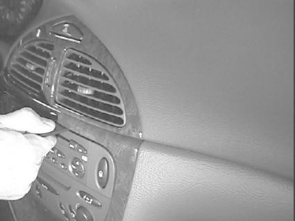 En hand justerar luftventiler i en bilinteriör.