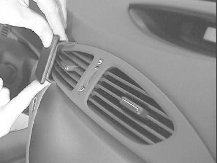 En hand installerar en del på luftventilen i en Renault Laguna.