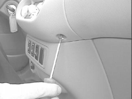 En person använder en skruvmejsel på interiören i en Nissan Almera Tino.