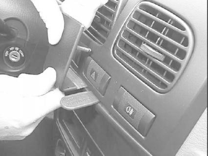 En hand installerar en monteringsbygel i en Kia Rio 01-05.